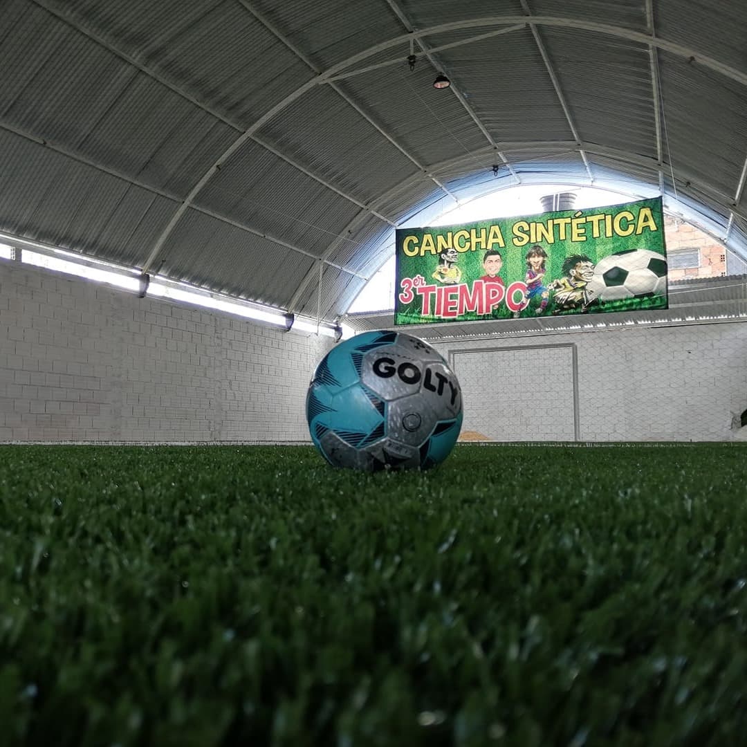 Detalle del balón sobre el pasto sintético